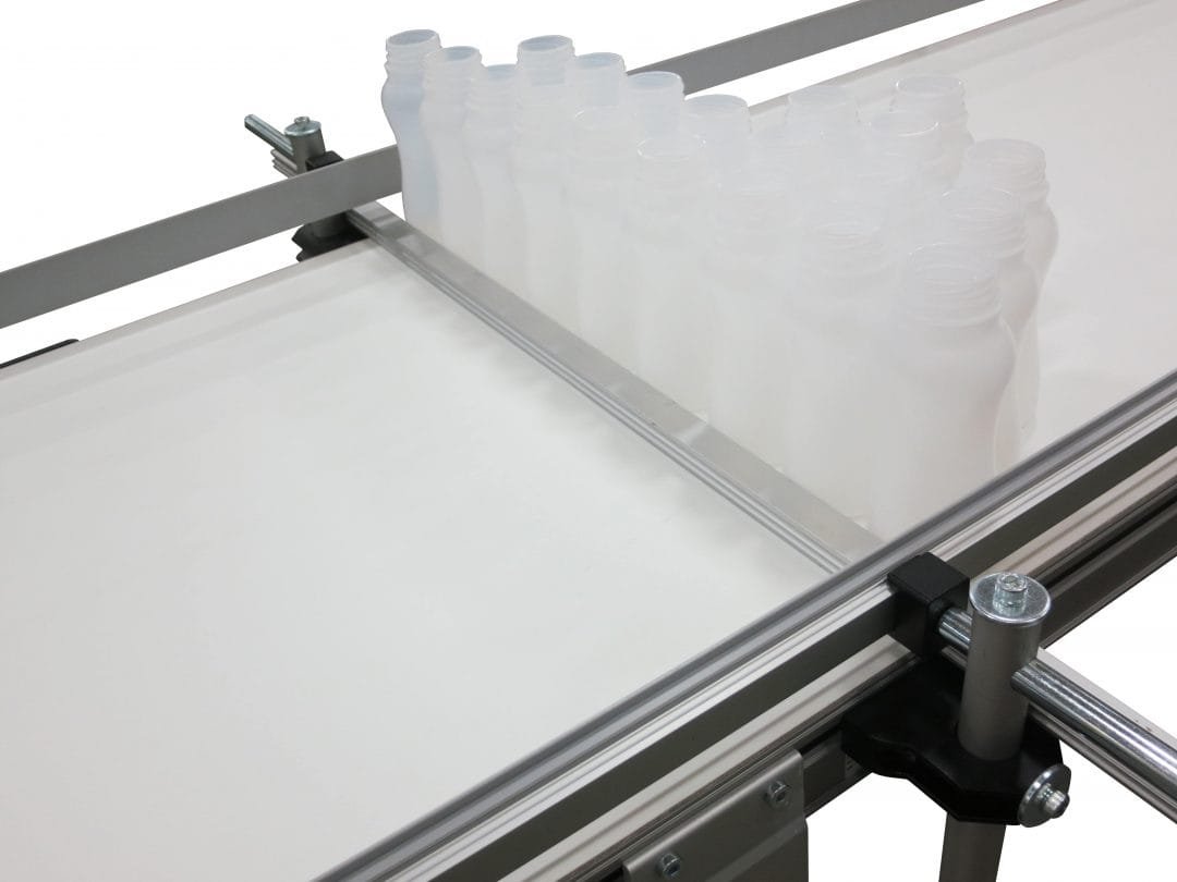 Containers held in a guided lane on a conveyor