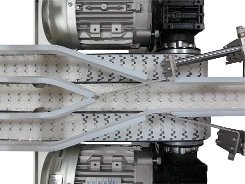 Powered side guide controlling product transfer