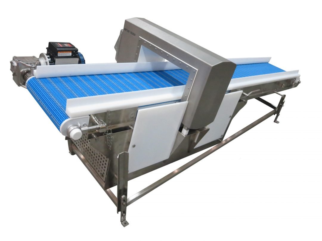 Close view of a conveyor belt passing through a metal detector aperture