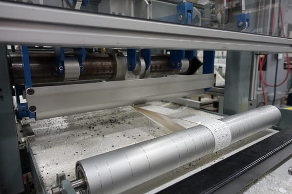 Flat parts held on a vacuum conveyor belt